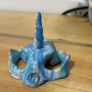 Front view of A marbled blue Kitty Corn Skull sculpture made by Cassandra.